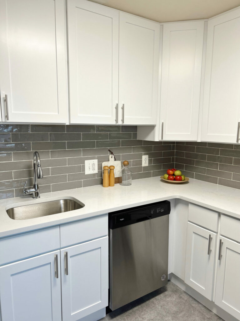 Renovated kitchen with white cabinets and stainless steel appliances.