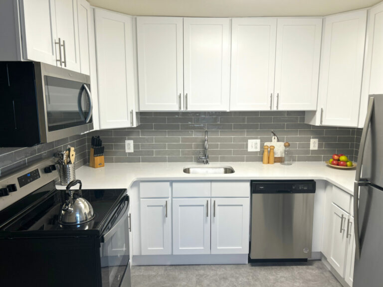 Renovated kitchen with white cabinets and stainless steel appliances.